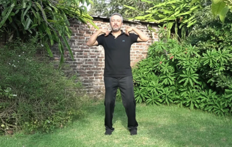 Postura de parado correcta con pulgares tocando hombros. Técnica psicofísica.